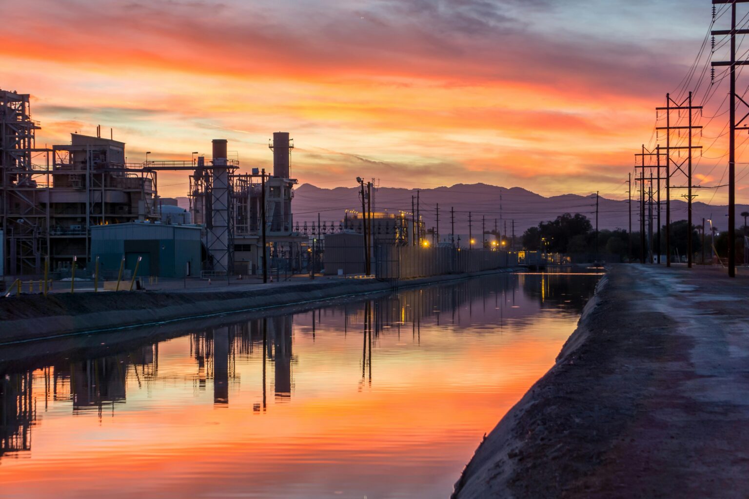 Stunning reflection of industrial structures against a vibrant sunset in Tempe, Arizona.